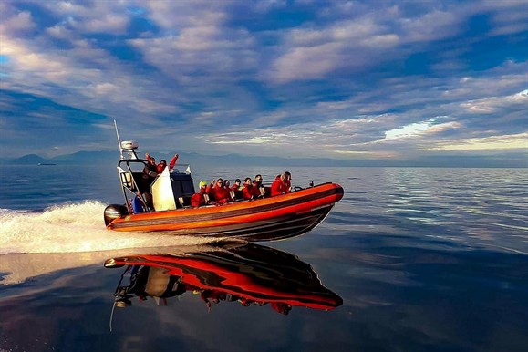 Whale watching boat filled with passengers on the water heading out to sea Whale watching boat filled with passengers on the water heading out to sea